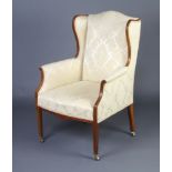 An Edwardian inlaid mahogany open arm chair upholstered in yellow material, raised on square