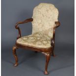 A 1920's Queen Anne style walnut open armchair raised on cabriole supports with upholstered back and