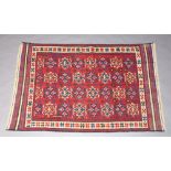 A white, blue and red ground Gulberjasta rug with stylised medallions to the centre within a multi