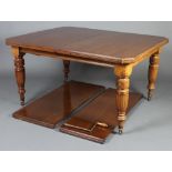 A Victorian mahogany extending dining table raised on turned and fluted supports with 2 extra leaves