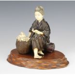 A Japanese Meiji period bronze and ivory mounted figure of a girl sitting on a trunk with a basket