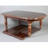 A Victorian style mahogany extending dining table raised on turned and reeded supports with 2