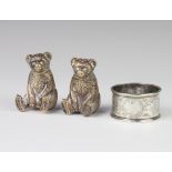 A pair of repousse silver condiments in the form of seated bears, Birmingham 1909 and a napkin