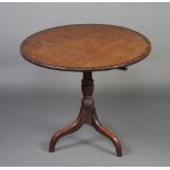 A circular crossbanded Georgian mahogany snap top tea table raised on a turned column and tripod