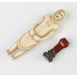 A carved ivory inuit standing figure of a man 9cm together with a hardstone mounted desk seal