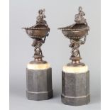 A pair of 19th Century bronze shell shaped vases surmounted by figures of Mermen and raised on