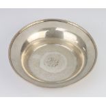 A circular sterling silver dish with monogram 19cm, 140 grams