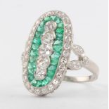 A platinum Art Deco style 5 stone diamond and emerald oval ring, size N