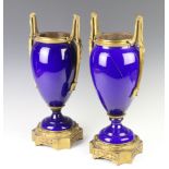 A pair of 19th Century Sevres style gilt metal mounted blue porcelain vases, raised on stepped
