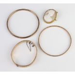 Three gold plated bangles and a cameo portrait brooch