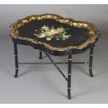 A Victorian black and floral patterned papier-mache tray, raised on an associated faux bamboo