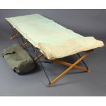 A military issue canvas folding camp bed together with a canvas kit bag