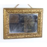 A 19th Century rectangular bevelled plate wall mirror contained in a carved gilt cushion shaped