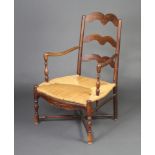 A 19th Century French elm ladder back open arm carver chair with woven rush seat on turned