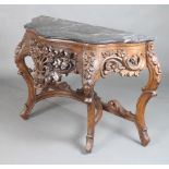 A carved and pierced walnut console table of serpentine outline with black veined marble top, raised