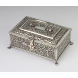 An Indian silver rectangular box chased with flowers on pad feet 17cm, 569 grams