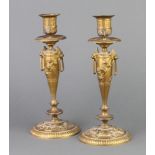 A pair of 19th Century French gilt metal candlesticks with vinery decoration and lion ring drop