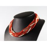 An 8 strand seed pearl and coral bead necklace with a yellow gold clasp 42cm