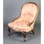 A Victorian carved rosewood show frame tub back chair with dolphin arms, the seat of serpentine