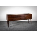 A ROSEWOOD LOW SIDEBOARD, ITALIAN, 1960s, with four short drawers on tapering legs, 150cm (w) x 37cm