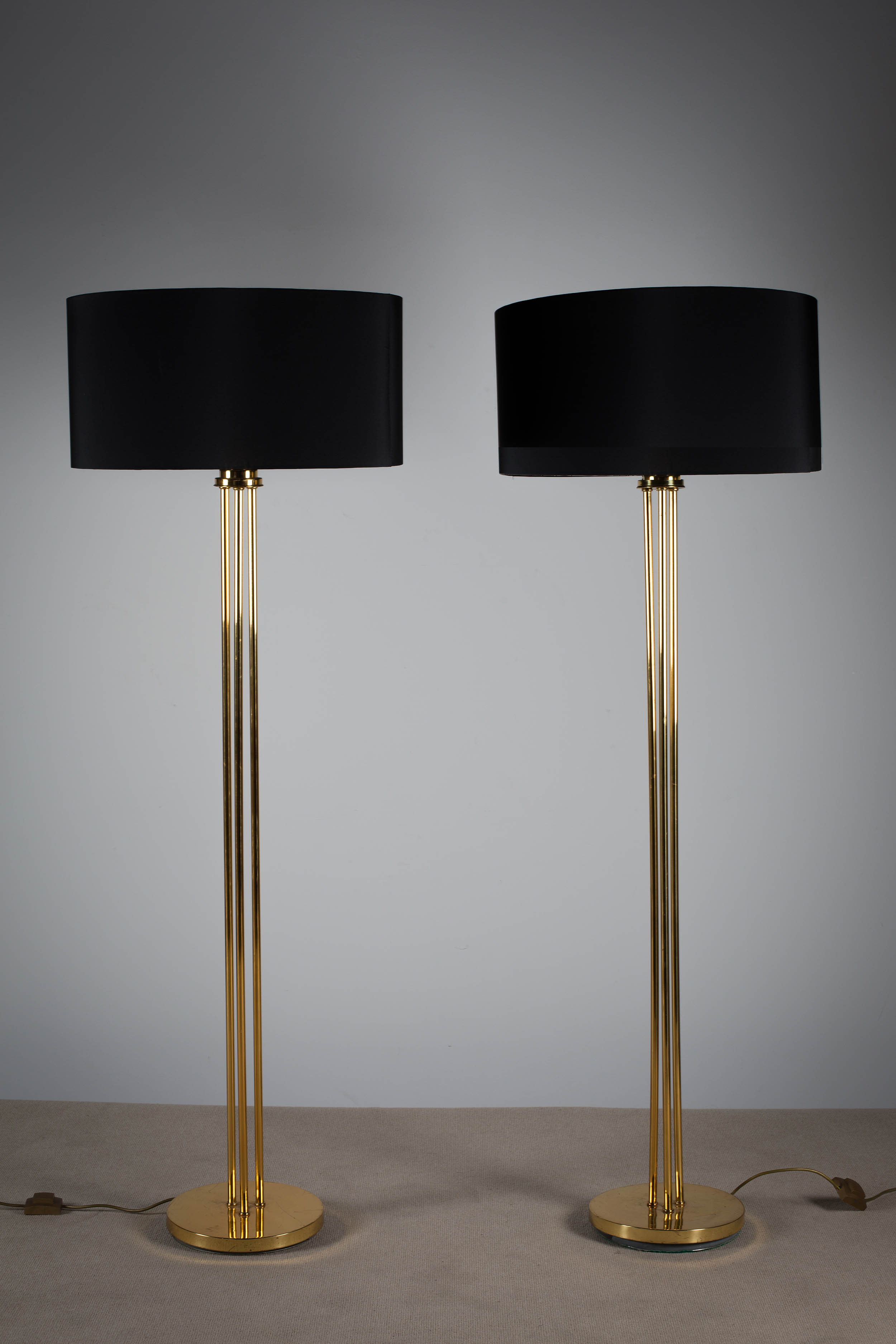 A PAIR OF TUBULAR BRASS STANDARD LAMPS, 1970s, on circular bases, each 177cm (h)