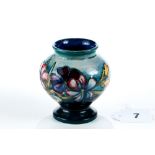 A 20TH CENTURY MOORCROFT POTTERY VASE, blue/green ground decorated with spring flowers, impressed