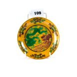 A CHINESE YELLOW GROUND PORCELAIN SAUCER DISH decorated in green/manganese with a five claw dragon