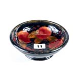 A 20TH CENTURY MOORCROFT POTTERY CIRCULAR BLUE GROUND BOWL decorated pomegranates and leaves,