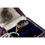 A 9CT YELLOW GOLD THREE-STONE SAPPHIRE RING with diamond set border, size P, stamped 375,