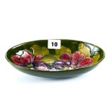 A 20TH CENTURY MOORCROFT POTTERY OVAL GREEN GROUND BOWL decorated with flower heads and leaves,