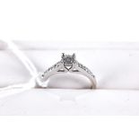 A 9CT WHITE GOLD SOLITAIRE DIAMOND RING with diamond set shoulders, size L, stamped 375,