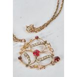 AN EDWARDIAN ART NOUVEAU PERIOD YELLOW METAL RED STONE AND SEED PEARL PENDANT on a yellow metal