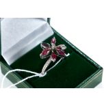 A WHITE GOLD RUBY AND DIAMOND FLOWER-HEAD RING with textured shank, size M 1/2, approximately 5.1