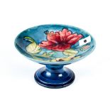 A 20TH CENTURY MOORCROFT BLUE GROUND TAZZA decorated with hibiscus, impressed marks and WM in