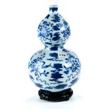 A CHINESE UNDERGLAZE BLUE AND WHTE DOUBLE GOURD SHAPE PORCELAIN VASE decorated with flowers and