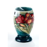 A 20TH CENTURY MOORCROFT POTTERY VASE, blue/green ground decorated with flowers and stiff leaves,