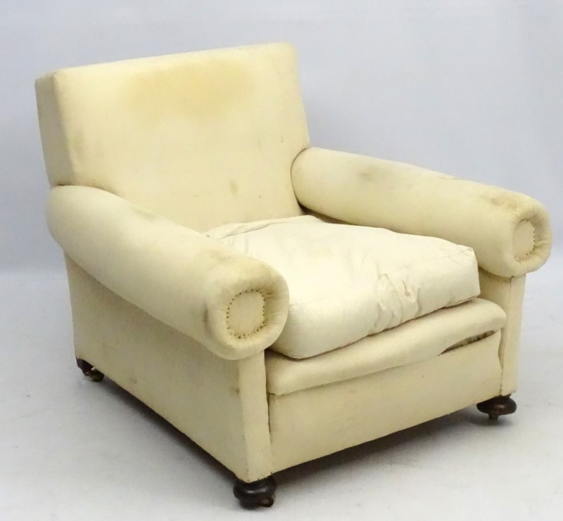 A late Victorian upholstered and overstuffed armchair with walnut bun feet.