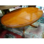 A 20thC oval cherry wood occasional table on a pedestal base with lions paw feet