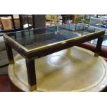 A coffee table with smoked glass top and brass furniture CONDITION: Please Note -