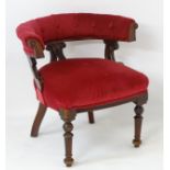 A late 19thC mahogany captains chair with buttoned upholstered backrest,