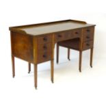 An early / mid 20thC mahogany desk / writing table with long central drawer flanked by three