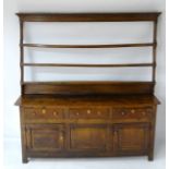 A late 18thC oak dresser with a three tier plate rack having a moulding cornice.