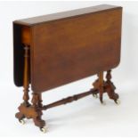 A late 19thC walnut Sutherland table with dual drop flap mechanism,