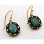 A pair of yellow metal drop earrings set with green and white stones .