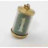A Vintage 9ct gold pendant charm of canister form containing a £1 note and marked 3/4" high