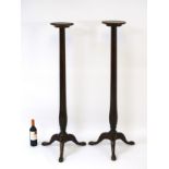 A pair of Victorian mahogany torcheres with dished tops and turned tapering stem,