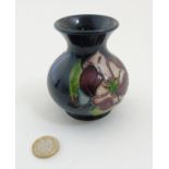 A 1994 Moorcroft Magnolia vase on dark blue ground, makers mark to base,