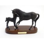 A Royal Doulton 'Black Beauty and Foal' equestrian group on a wooden plinth. Approx.