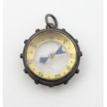 Charm: a double sided ship's wheel compass, with hanging loop,