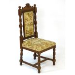 A Victorian oak chair with shaped cresting rail having rosette carving flanked by turned finials,